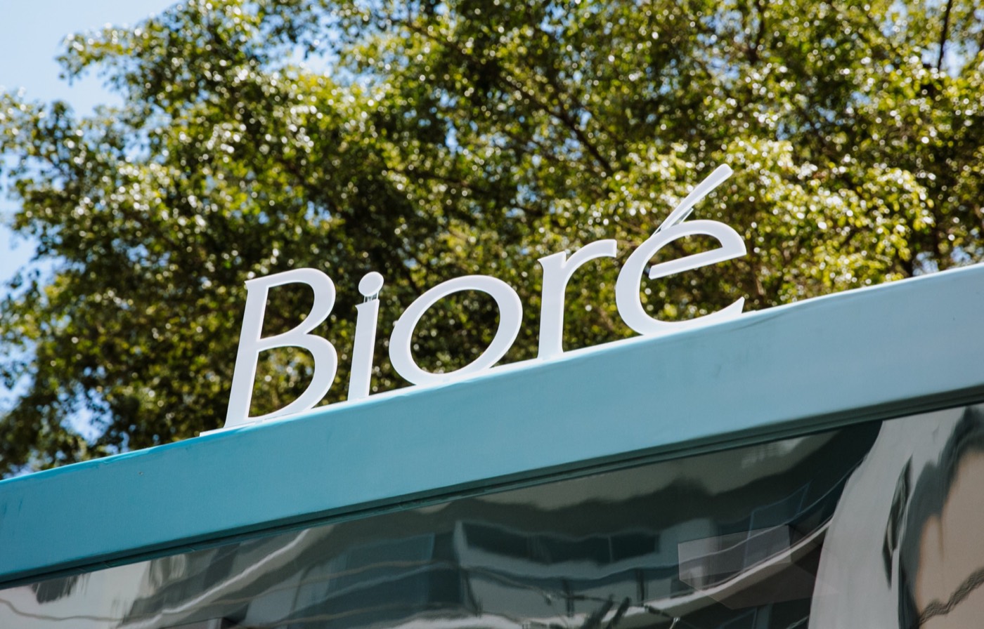 "Bioré" sign in white letters on a blue structure, with treetops in the background