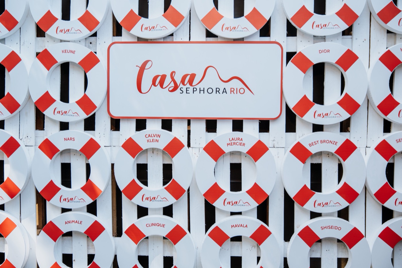 Wall of white and red life rings with brand names and a "Casa SEPHORA RIO" sign in the center