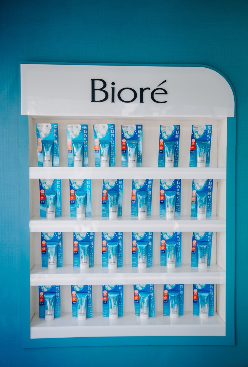 White display with "Bioré" lettering and shelves of blue packages on a blue wall