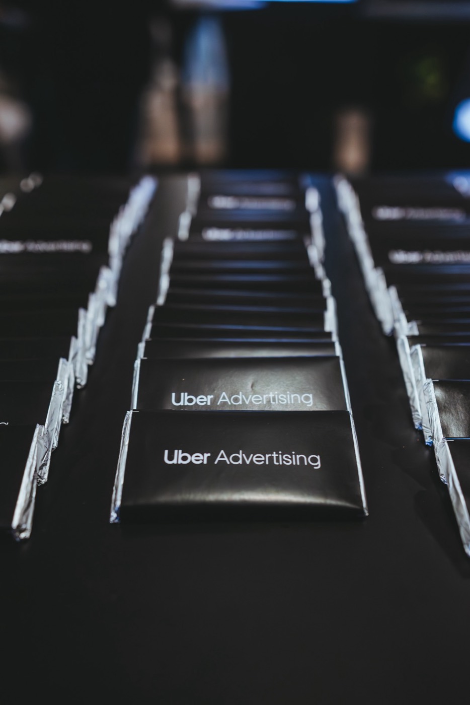 Rows of bars in black wrapping reading "Uber Advertising" on a dark surface, in close-up