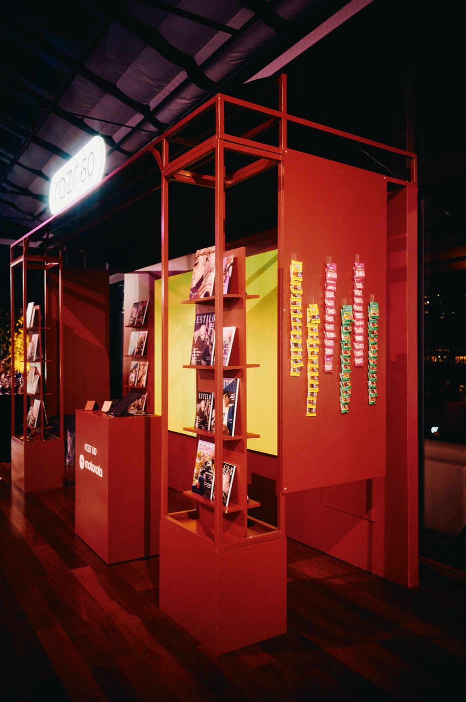 Red booth with magazine racks, hanging colorful strips and a lit "razr 60" sign